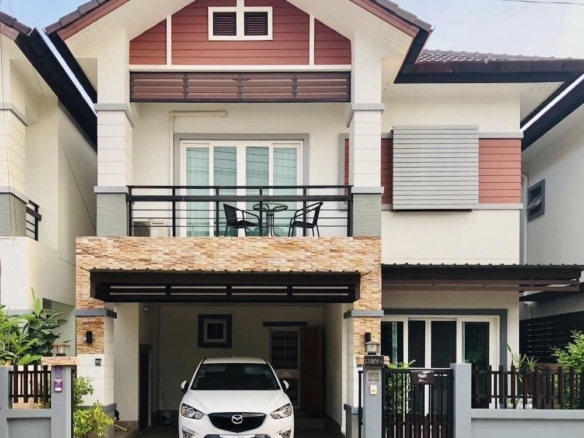 Modern two-story home with a stone-clad carport and a white Mazda SUV parked in the driveway, balcony above.