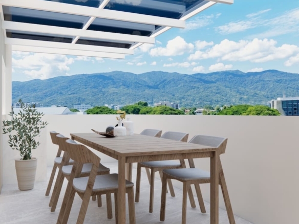 Rooftop patio with a wooden dining table and six chairs, potted plant, and a glass-covered trellis against a mountain landscape.